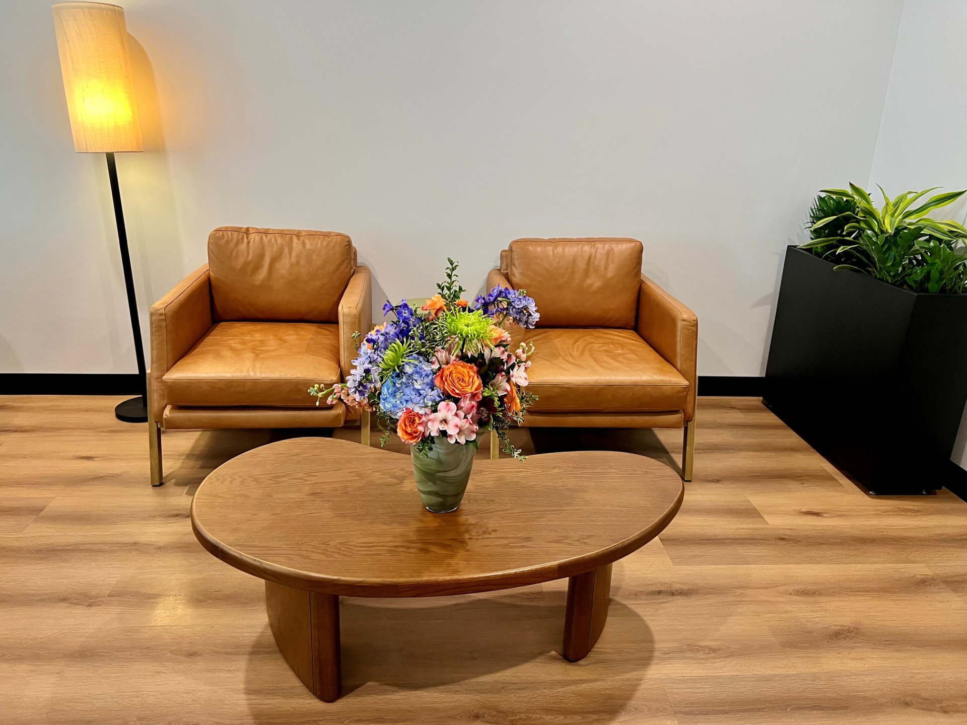 The second-floor lobby of the Dallas Therapy Associates office on Greenville Avenue — two tan leather armchairs, a wood coffee table, and fresh flowers