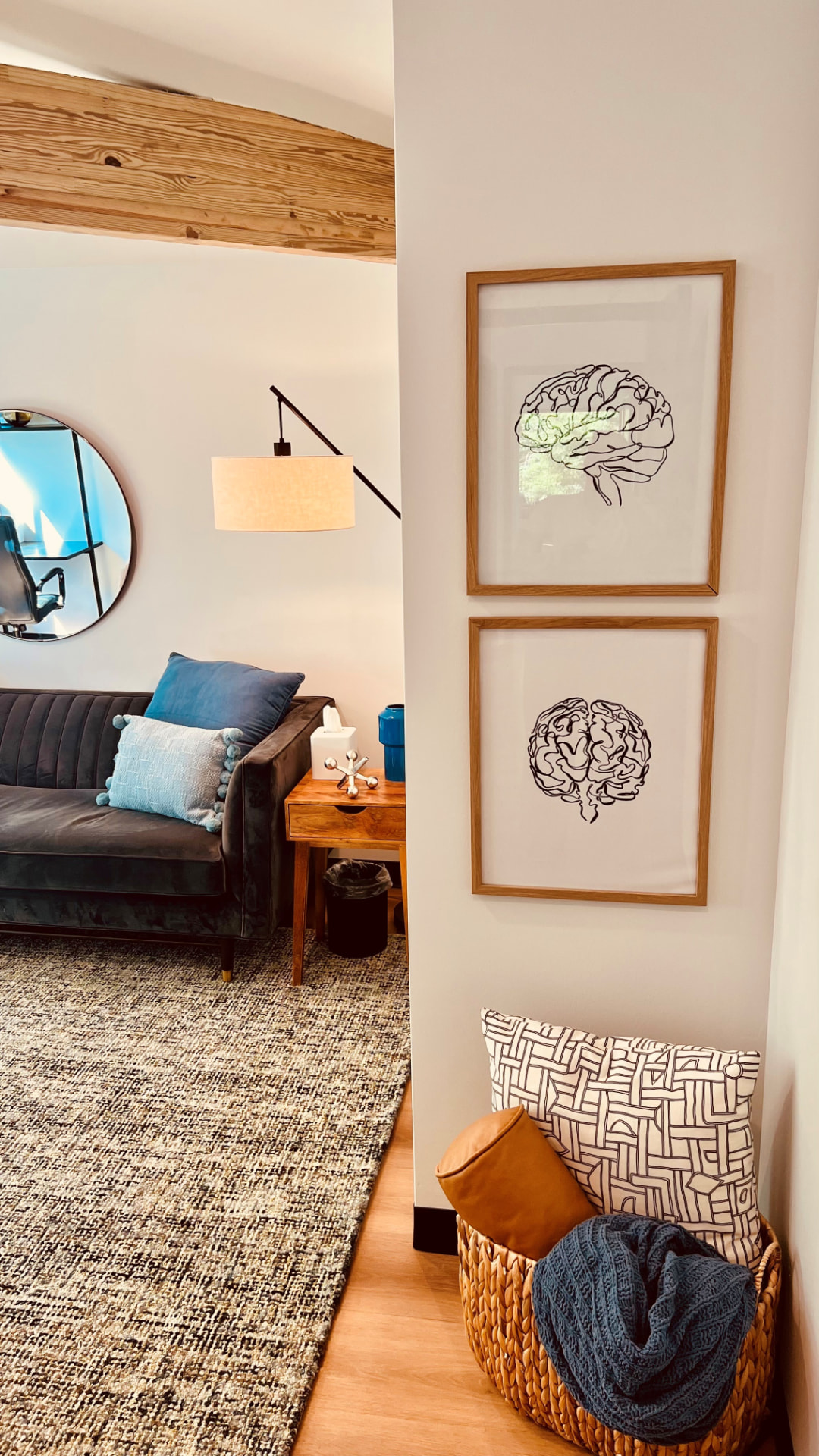 Framed brain artwork and a basket of blankets outside a therapy room at Dallas Therapy Associates