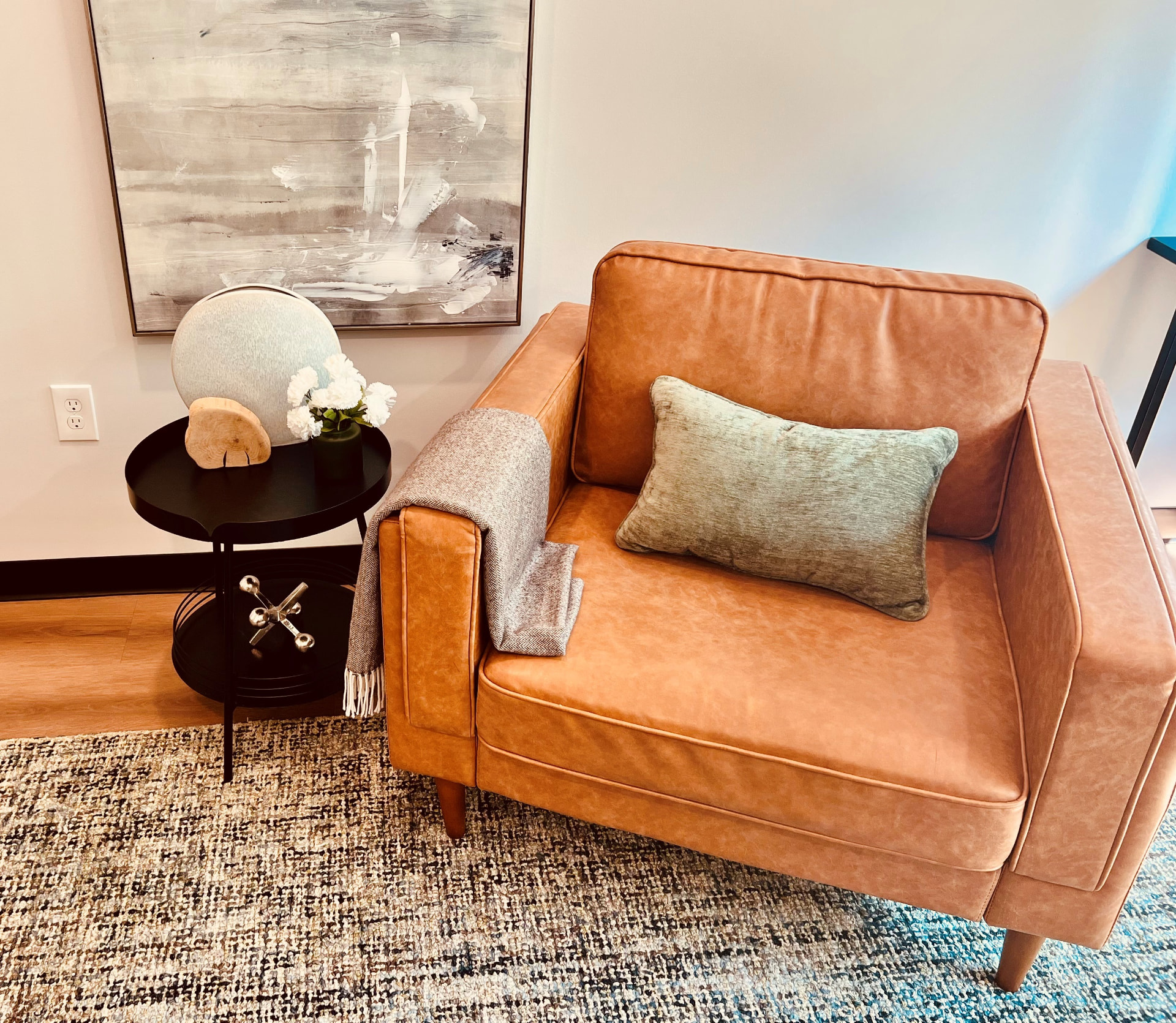 A caramel leather chair with a wool throw and side table in a Dallas Therapy Associates office